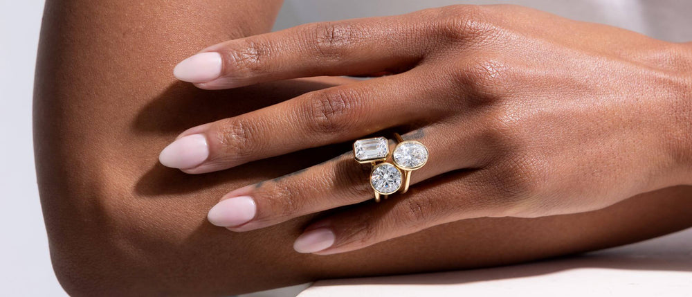 Close-up of Woman’s hand wearing bezel set lab-grown diamond engagement ring by Jean Dousset