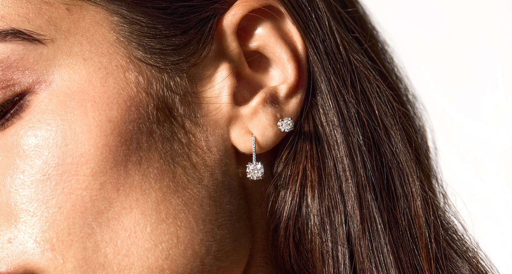Female model wearing Jean Dousset lab diamond earrings in banner visual
